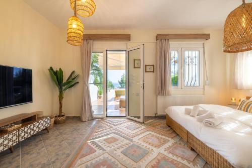 a bedroom with a large bed and a television at Halkidiki Boho Pool Beach House in Gerakini