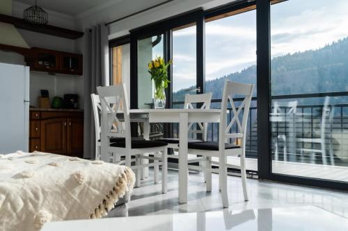 una sala da pranzo bianca con tavolo e sedie di ApartView Szkolna Szczyrk by Rent like home a Szczyrk