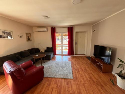 a living room with a couch and a television at Apart Zen House in Borča