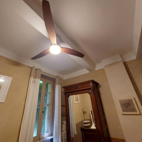 Cette chambre comprend un ventilateur de plafond et un miroir. dans l'établissement Le Patio Des Cigales, à Roquefort-des-Corbières