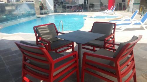 two chairs and a table next to a pool at Hotel Atrium Plaza in Barranquilla