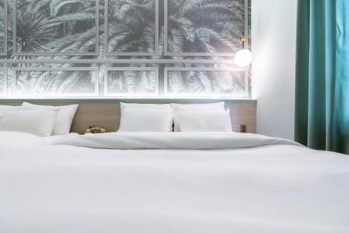 a bedroom with a white bed with white pillows at Hotel Ippda Wonju in Wonju
