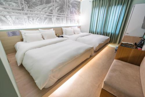 a room with two large beds in it at Hotel Ippda Wonju in Wonju