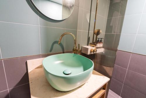 a bathroom with a green sink on a counter at Hotel Ippda Wonju in Wonju
