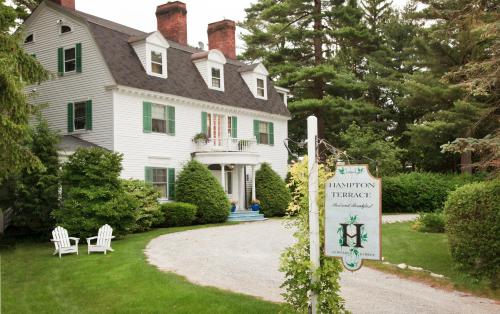 a white house with a sign in front of it at Hampton Terrace Inn in Lenox