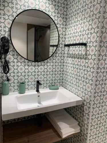 a bathroom with a sink and a mirror at Hostal Ainhoa in Tafalla