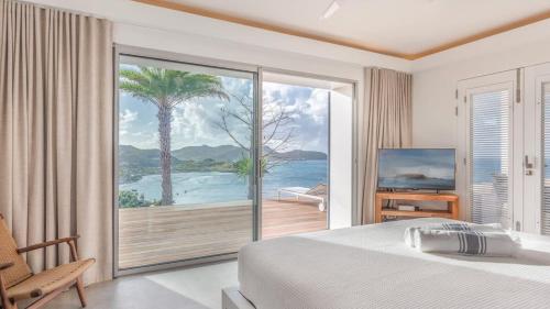 a bedroom with a bed and a view of the ocean at Grand Classic Villa with Stunning Islands Views in Quartier de Lorient