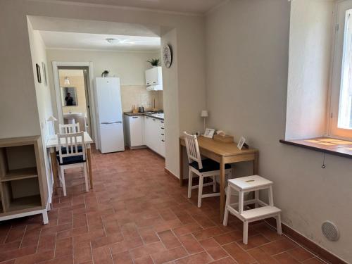 a kitchen with a table and chairs and a refrigerator at Oltrella Country House in Ponte Nizza