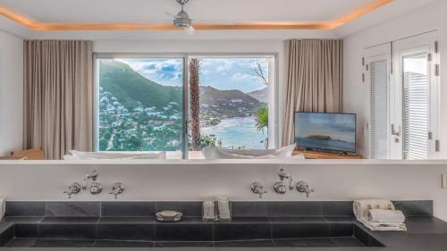 a bathroom with a tub with a large window at Grand Classic Villa with Stunning Islands Views in Quartier de Lorient