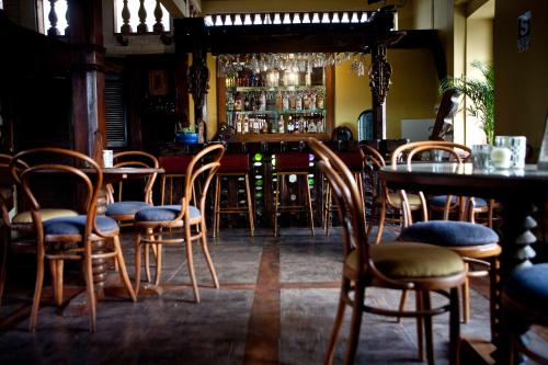a restaurant with a bar with wooden chairs and tables at Hotel & Hacienda El Carmelo in Ica
