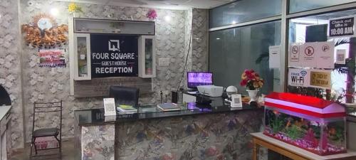 a reception desk in a restaurant with a fish tank at Hotel Four Square in Dīgha