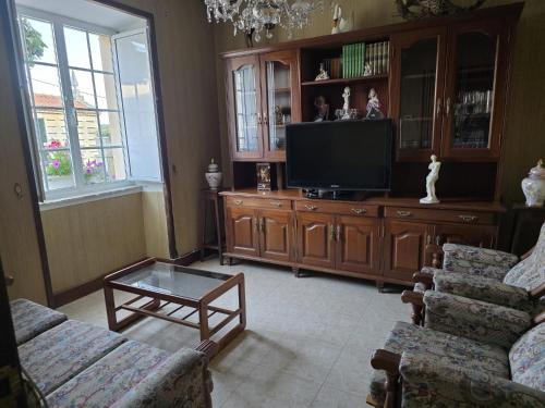 a living room with a couch and a tv at Villa Janeixa in Lariño