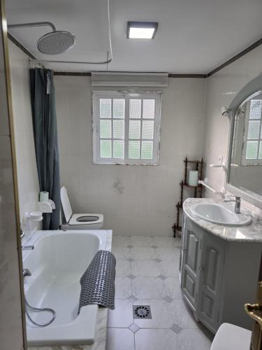 a bathroom with a tub and a sink and a toilet at Villa Janeixa in Lariño