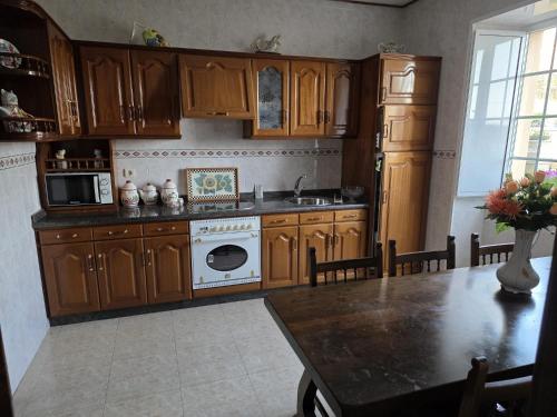 a kitchen with wooden cabinets and a white stove top oven at Villa Janeixa in Lariño