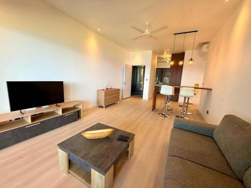 Una sala de estar con un sofá y un televisor de pantalla plana. en Apartment in flic en Flac, en Flic en Flac