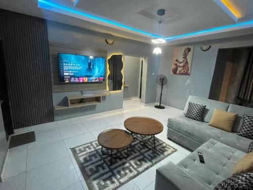 a living room with a couch and a table and a tv at Amwallode Modern Luxury Apartment in Ibadan Central in Ibadan