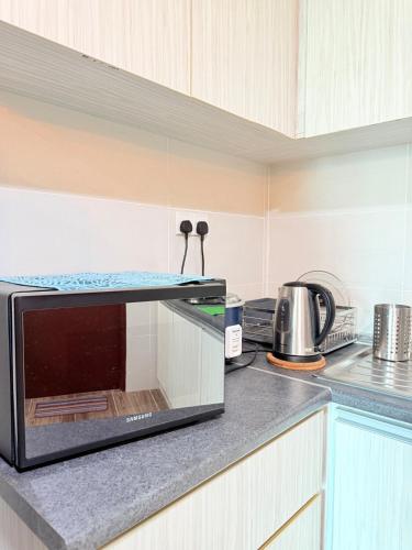a microwave oven sitting on top of a kitchen counter at Kuching Vivacity Jazz Suite 4 YM Homestay 3 bedroom 2 bathroom in Kuching
