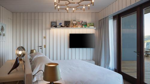 a bedroom with a bed and a tv on the wall at Exclusive Villa in a Privileged Place in Gustavia