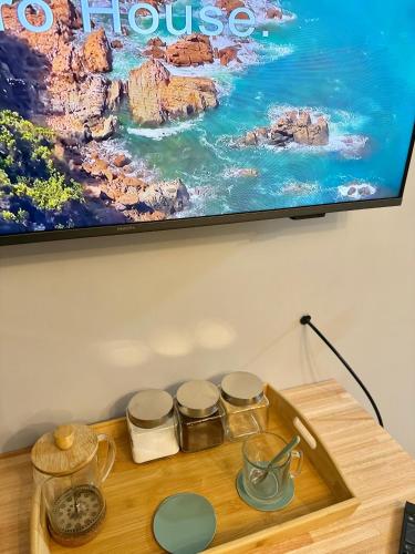 a tv hanging on a wall above a table with jars at Blue Ocean in Mar del Plata