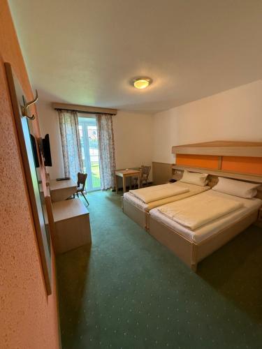 a hotel room with two beds and a table at Zur Post Wellness und Sporthotel in Tännesberg