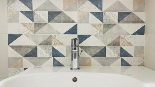 a sink in a bathroom with a tile wall at Albergo Villa Denny in Rimini