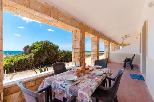 Un comedor con mesa y vista al mar. en Veranda sul Mare by BarbarHouse, en Punta Prosciutto
