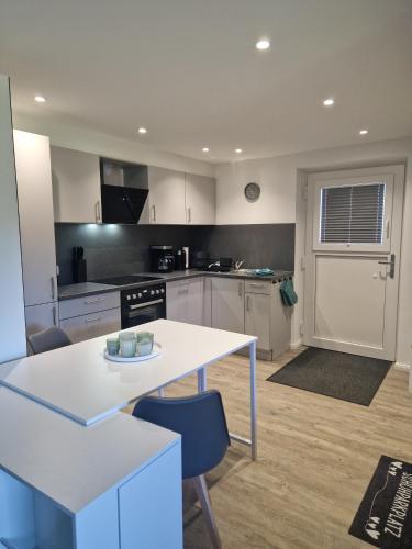a kitchen with white cabinets and a table and chairs at Ferienwohnung Landglück in Haale