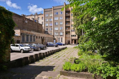 a city street with cars parked in front of buildings at Grīziņparka apartaments in Rīga