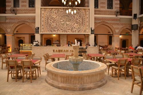 a restaurant with a fountain and tables and chairs at TASHAN1699 Otel ve Restoran in Amasya