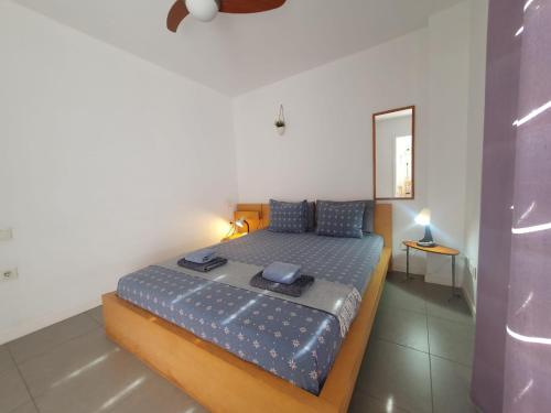 a bedroom with a bed with a blue comforter at Alquilaencanarias-Medano Los Martines beachfront A in El Médano
