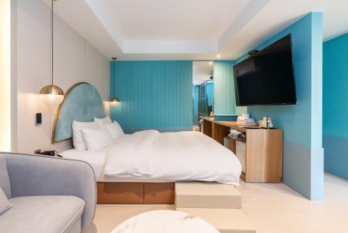 a hotel room with a bed and a tv at Hotel Ippda Wonju in Wonju
