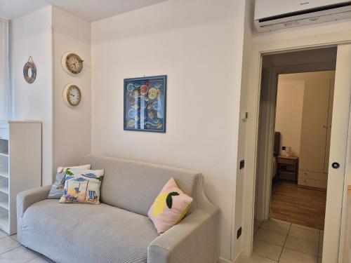 a living room with a couch and a clock on the wall at Casa Grace - SANTA MONICA in Lido di Jesolo