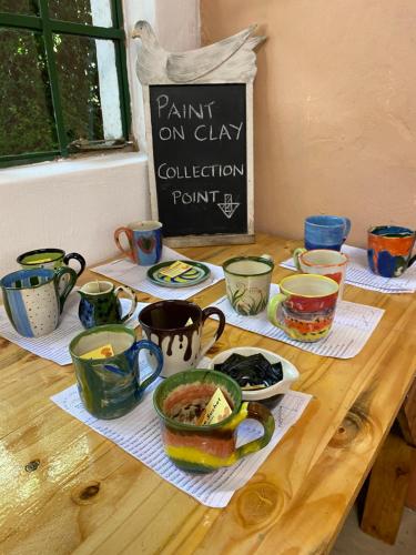 a wooden table with various cups and dishes on it at Sani Lodge & Cottages in Sani Pass