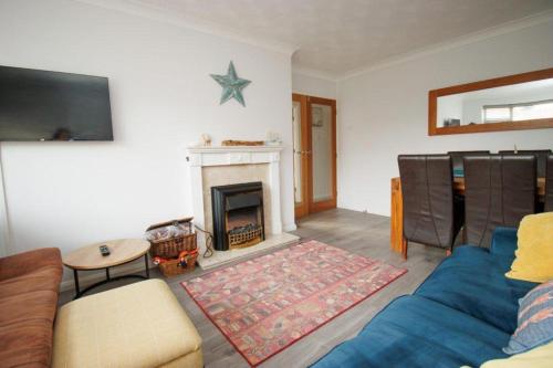 a living room with a blue couch and a fireplace at 2 Bed Bungalow - Sleeps 4 - Pets - Parking - Wifi in Filey