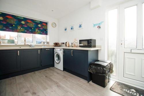 a kitchen with a sink and a washing machine at 2 Bed Bungalow - Sleeps 4 - Pets - Parking - Wifi in Filey
