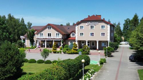 a hotel in a park with a building at Hotel Chabrowy Dworek in Teresin