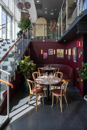 a dining room with tables and chairs and stairs at Radisson Blu Hotel Uppsala in Uppsala