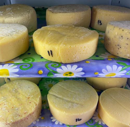 a group of cheeses on a plate with flowers at Sani Lodge & Cottages in Sani Pass