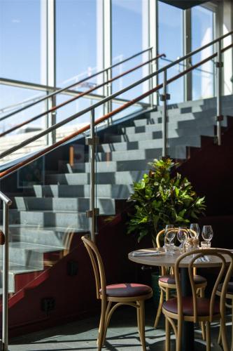 a table and chairs in a room with stairs at Radisson Blu Hotel Uppsala in Uppsala