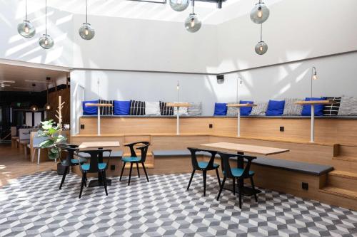 a restaurant with tables and chairs and blue chairs at Scandic Helsinki Aviacongress in Vantaa