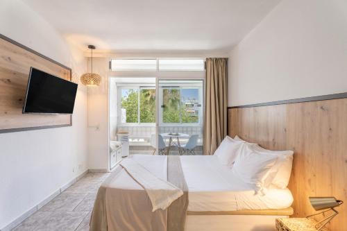 a hotel room with a bed and a television at Hand Made Suite Costa del Silencio in Costa Del Silencio