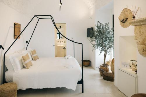 a bedroom with a white bed with a black frame at Corte Manfredi in Alessano