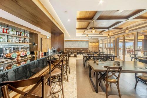 a restaurant with tables and chairs and a bar at Radisson Resort Ras Al Khaimah Marjan Island in Ras al Khaimah