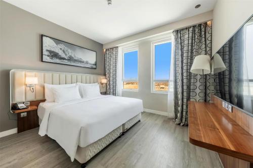 a bedroom with a large bed and a large window at Radisson Resort Ras Al Khaimah Marjan Island in Ras al Khaimah