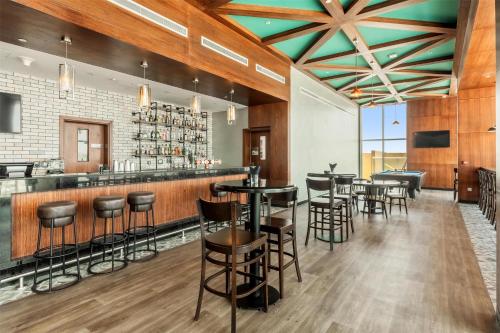 a bar in a restaurant with bar stools at Radisson Resort Ras Al Khaimah Marjan Island in Ras al Khaimah