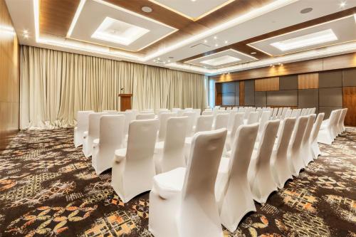 a conference room with white chairs and a podium at Radisson Resort Ras Al Khaimah Marjan Island in Ras al Khaimah