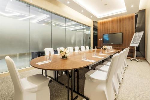 a conference room with a long table and white chairs at Radisson Resort Ras Al Khaimah Marjan Island in Ras al Khaimah