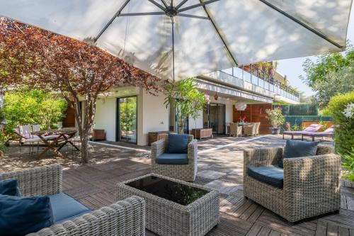 un patio extérieur avec des chaises et un parasol dans l'établissement Appartement de la Colline - Welkeys, à Nice
