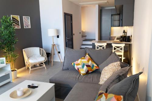 a living room with a gray couch and a kitchen at FOR LARGE FAMILIES, DUPLEX Vılla-305 in Cesme