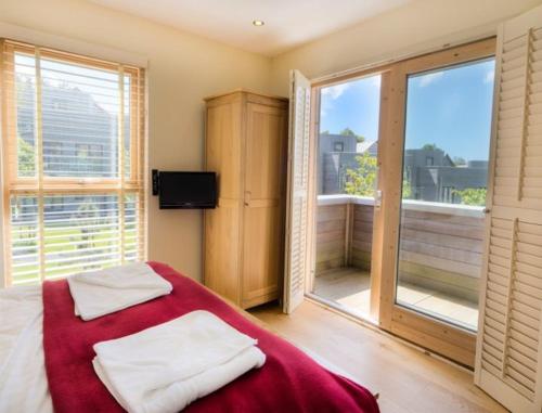 a bedroom with a bed and a large window at House 2 in Looe